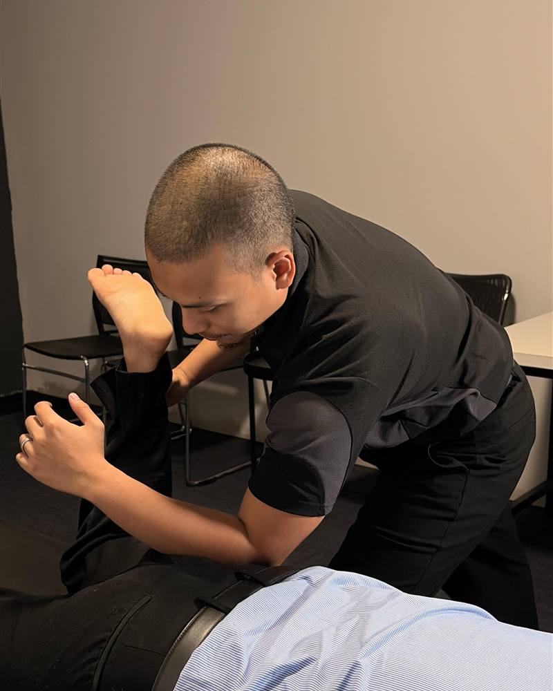 Dr Irfan Amzar assessing a patient during an initial Chiropractic consultation in Thornlie